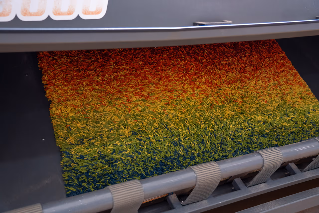 Colorful rug passing through an automated carpet cleaning machine